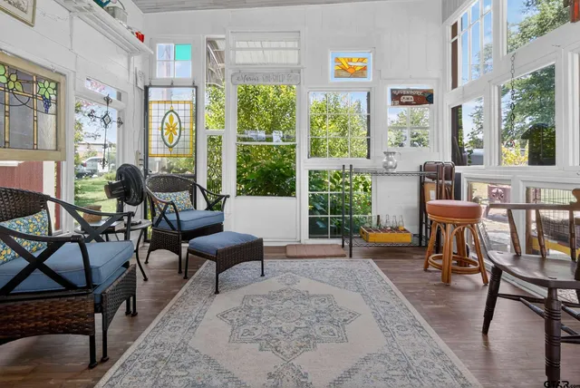 a view of a patio with couches chairs and a table and chairs under an umbrella