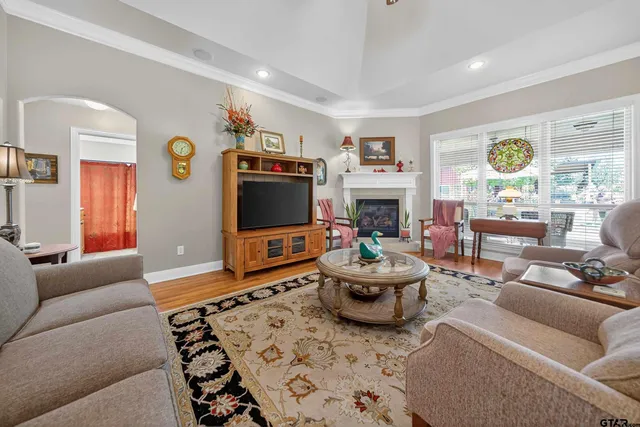 a living room with furniture a flat screen tv and a fireplace