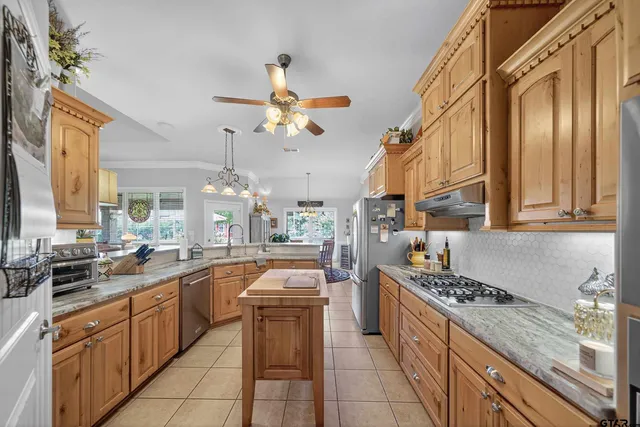 a large kitchen with a large counter top space appliances and cabinets