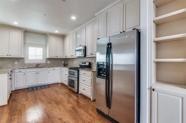 a kitchen with a refrigerator and a stove top oven