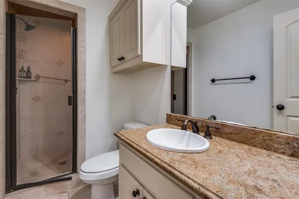a bathroom with a granite countertop sink toilet and shower