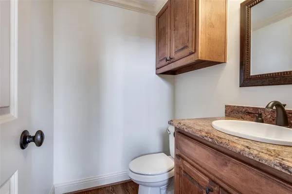 a bathroom with a granite countertop toilet sink and mirror