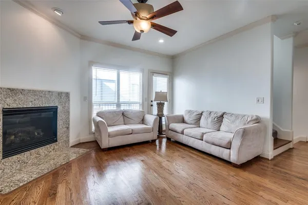 a living room with furniture a fireplace and a large window