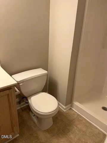a white toilet sitting next to a shower