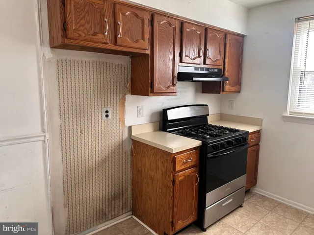 a kitchen with stainless steel appliances granite countertop a stove and a microwave oven