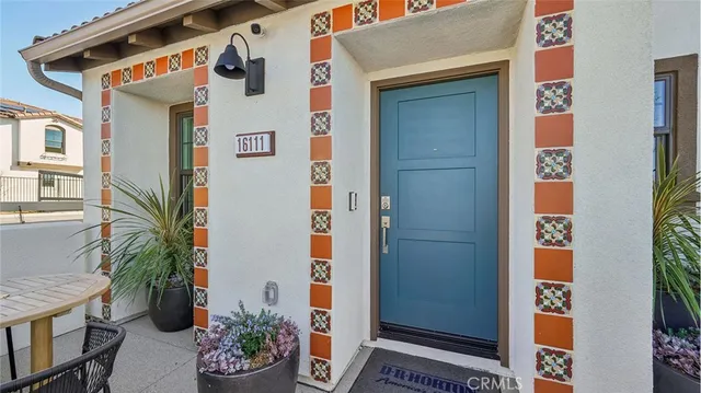 a view of a house with a potted plant ana a small yard