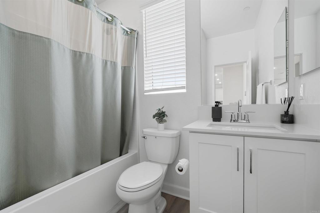 2402 Cascalote Loop San Diego, CA 92154 - Photo 27 of 35 a bathroom with a toilet a sink and a mirror