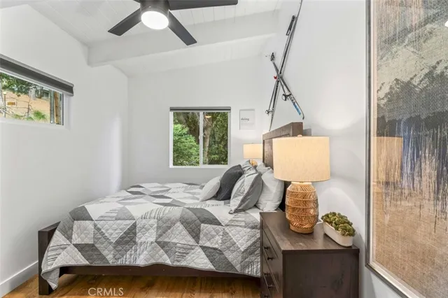 a living room with couch pool table and projector with wooden floor