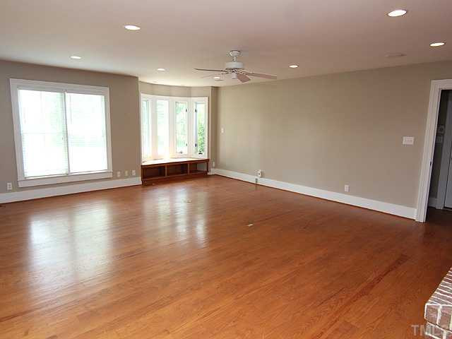 6422 Efland - Cedar Grove Road Cedar Grove, NC 27231 - Photo 3 of 12 an empty room with wooden floor and windows with curtains