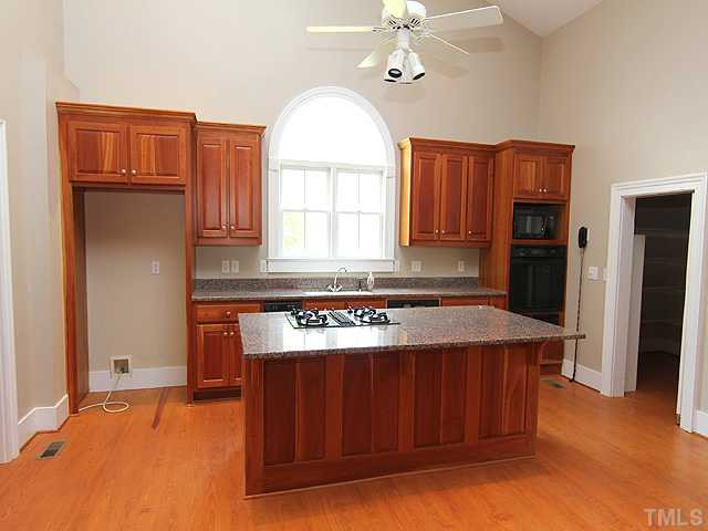 6422 Efland - Cedar Grove Road Cedar Grove, NC 27231 - Photo 6 of 12 a kitchen with a stove a refrigerator and a fireplace