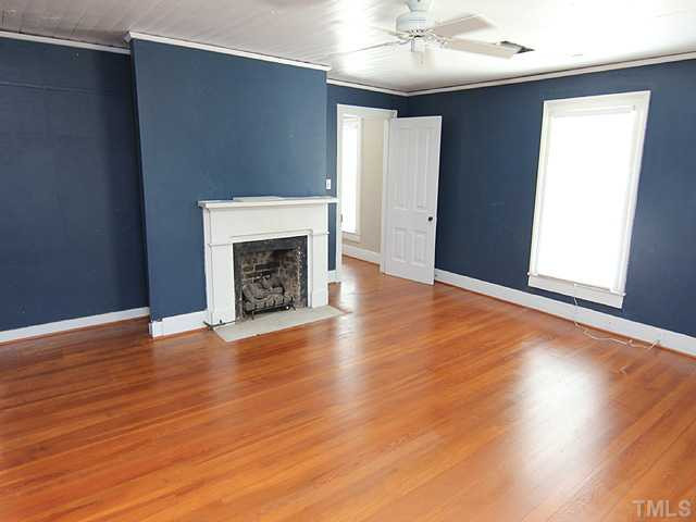 6422 Efland - Cedar Grove Road Cedar Grove, NC 27231 - Photo 8 of 12 an empty room with wooden floor fireplace and windows