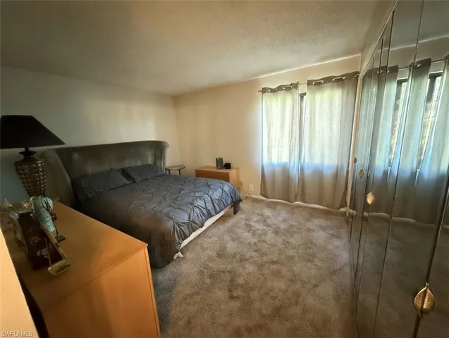 a bedroom with a bed and a dresser with the floor
