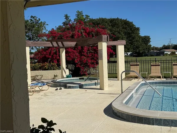 a view of a swimming pool with a couches and lounge chair