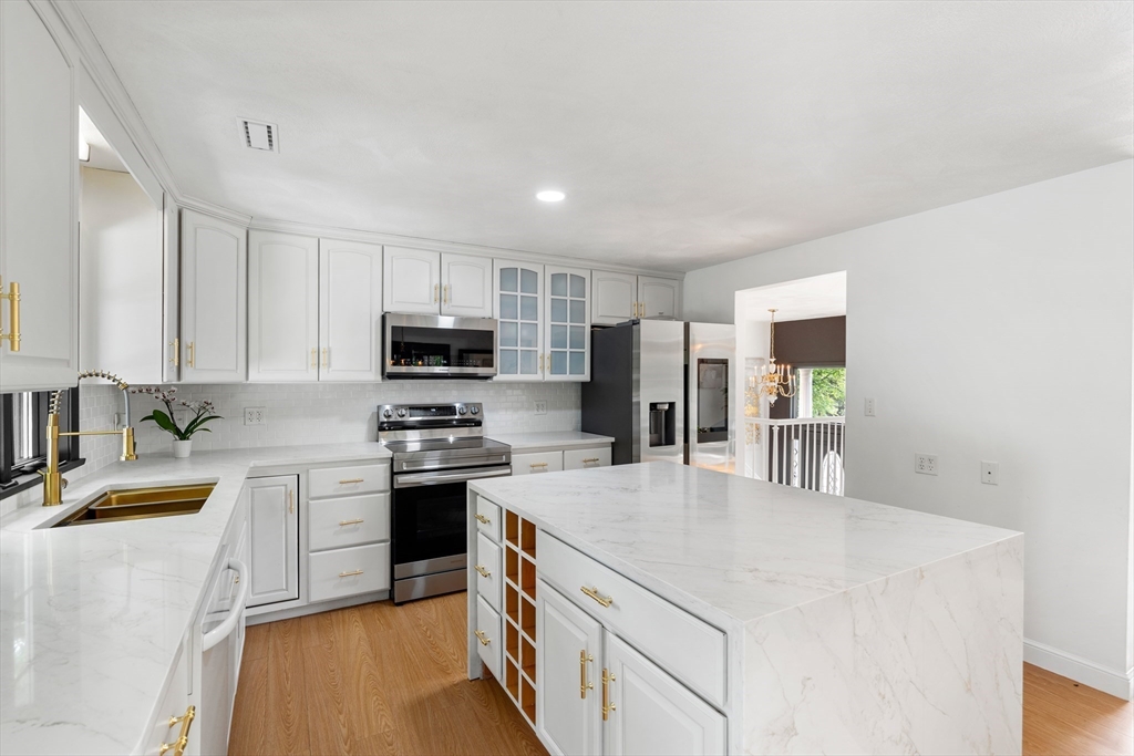 4 Blacksmith Way Saugus, MA 01906 - Photo 12 of 42 a kitchen with stainless steel appliances granite countertop a sink stove microwave and refrigerator