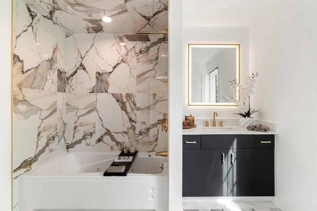 4 Blacksmith Way Saugus, MA 01906 - Photo 15 of 42 a bathroom with a sink and mirror with bathtub