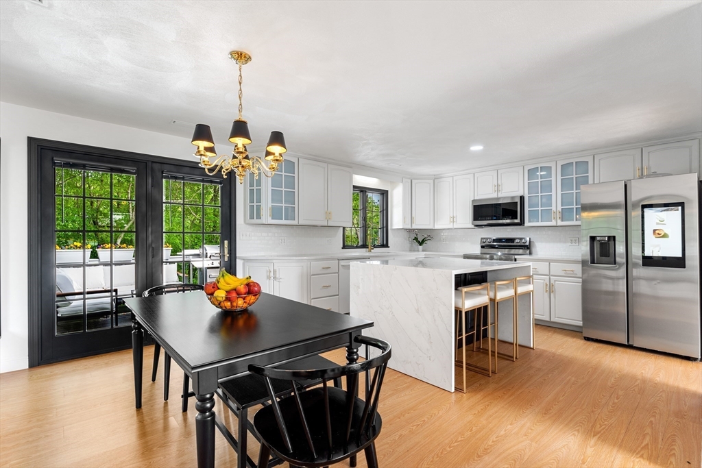 4 Blacksmith Way Saugus, MA 01906 - Photo 10 of 42 a kitchen with stainless steel appliances a dining table chairs stove refrigerator and wooden floor