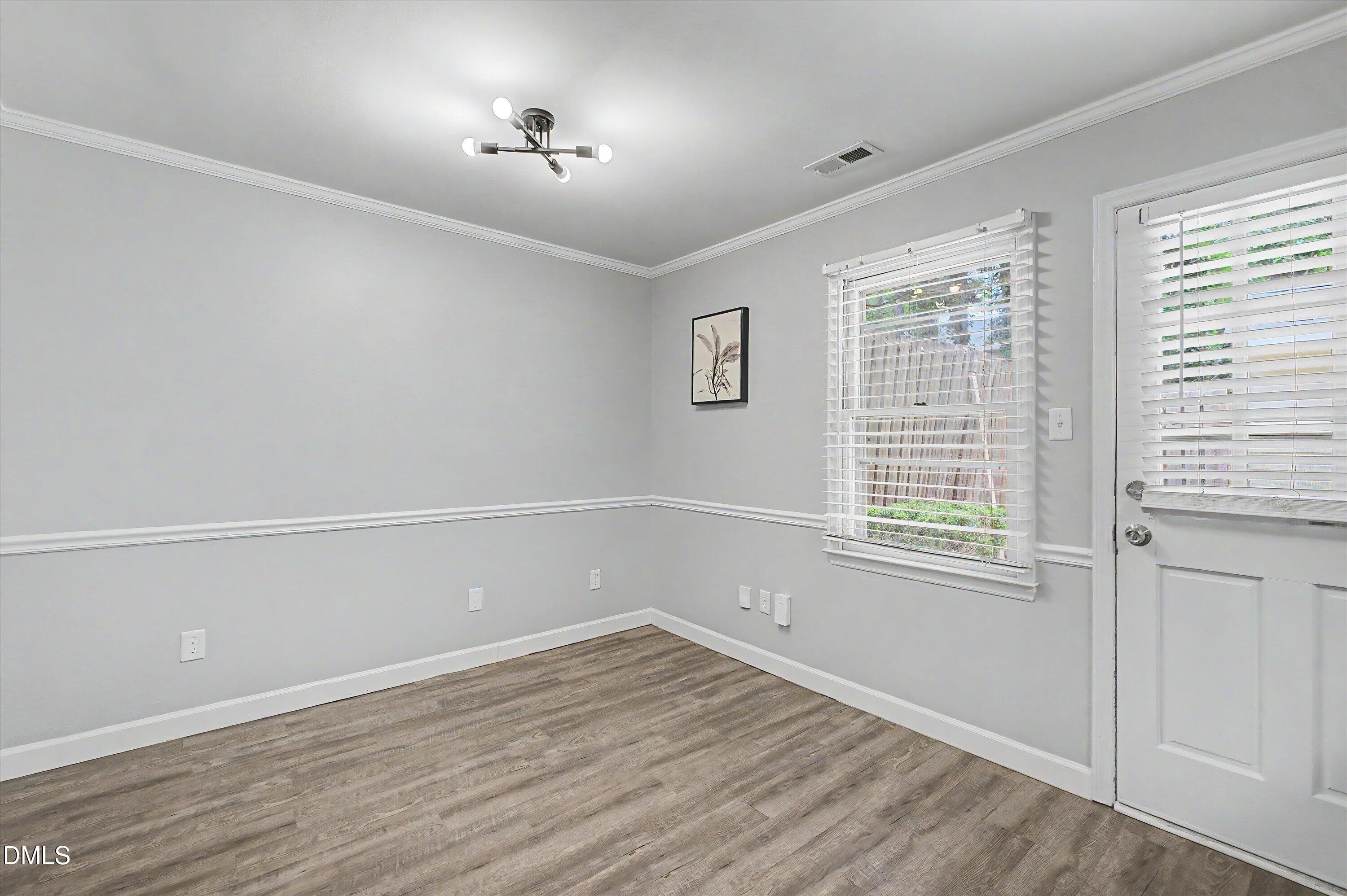 5519 Hamstead Crossing Raleigh, NC 27612 - Photo 12 of 33 an empty room with a window and wooden floor