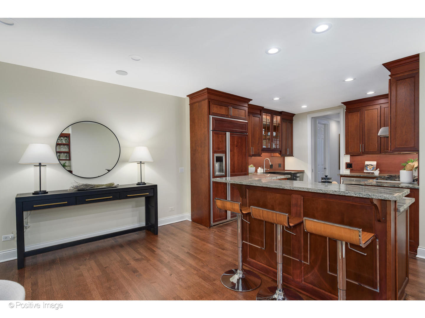 1112 North Dearborn Street, Unit 1 Chicago, IL 60610 - Photo 12 of 34 a kitchen with stainless steel appliances granite countertop a stove a sink dishwasher a microwave oven and a dining table with wooden cabinet