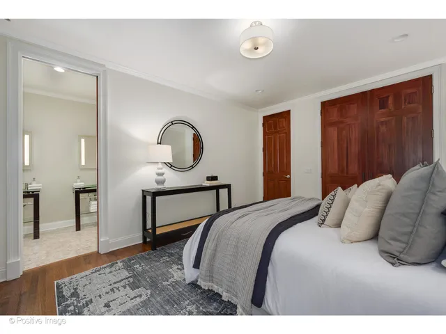 a bedroom with a bed a mirror and desk