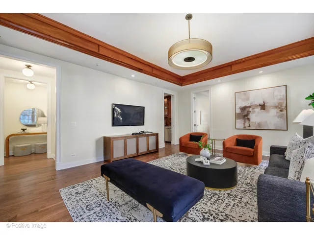 a living room with furniture a flat screen tv and kitchen view
