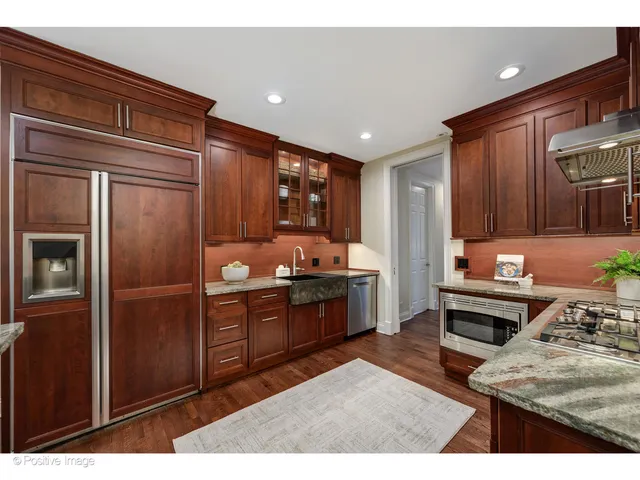 a kitchen with stainless steel appliances granite countertop a refrigerator and a stove