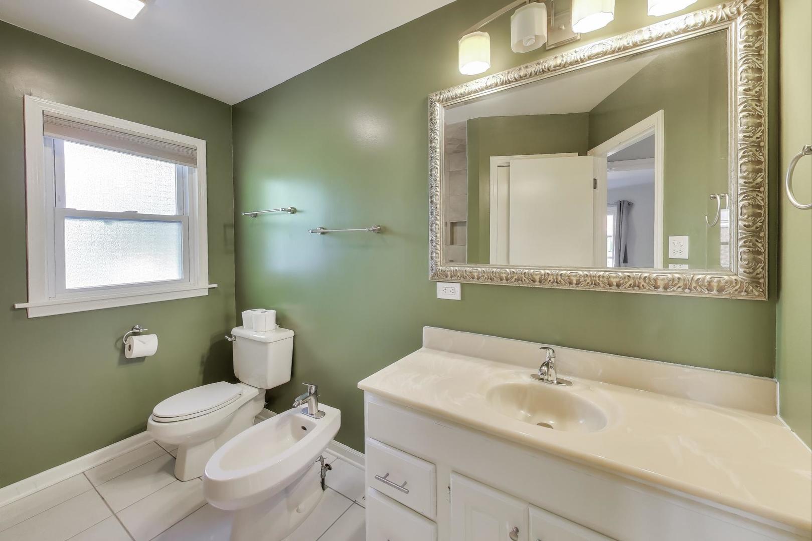 927 Half Day Road Highland Park, IL 60035 - Photo 9 of 20 a bathroom with a toilet sink and mirror