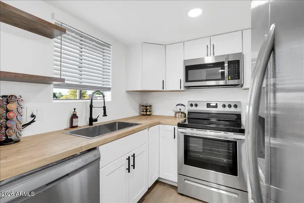 a kitchen with stainless steel appliances a stove microwave and sink