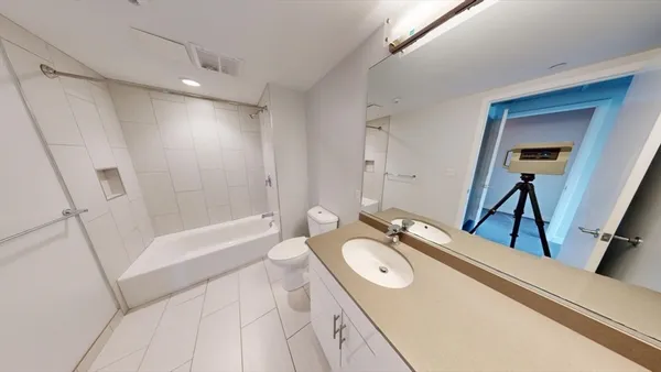 a bathroom with a granite countertop sink a mirror a vanity and a bathtub