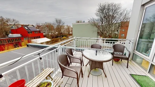 a balcony with table and chairs