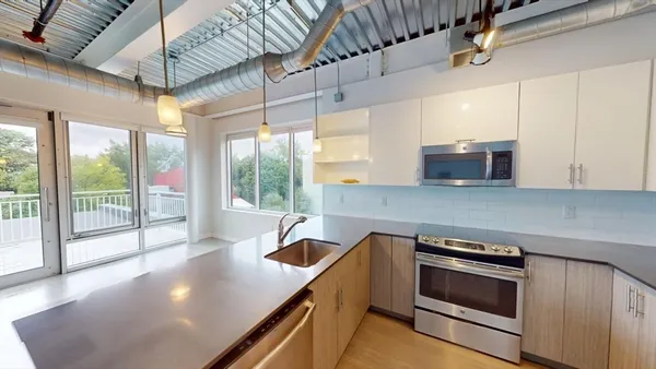 a kitchen with a stove a sink and a granite counter top