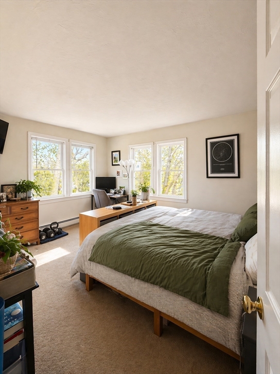 4 Westview Terrace, Unit 4 Natick, MA 01760 - Photo 5 of 9 a spacious bedroom with a bed a couch and a window