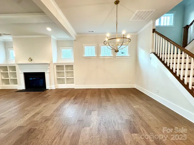 a view of empty room with wooden floor and fireplace