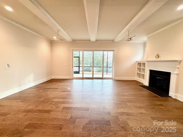 an empty room with windows and fireplace