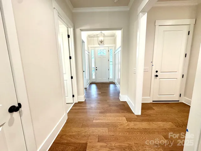a view of a hallway with wooden floor and closet area