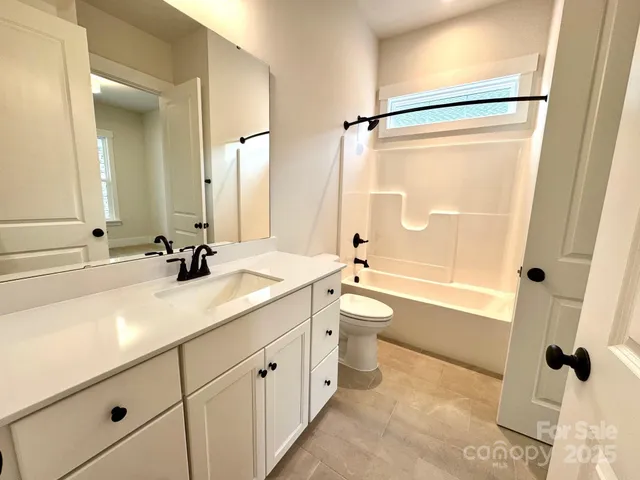 a bathroom with a granite countertop sink toilet a shower and a mirror