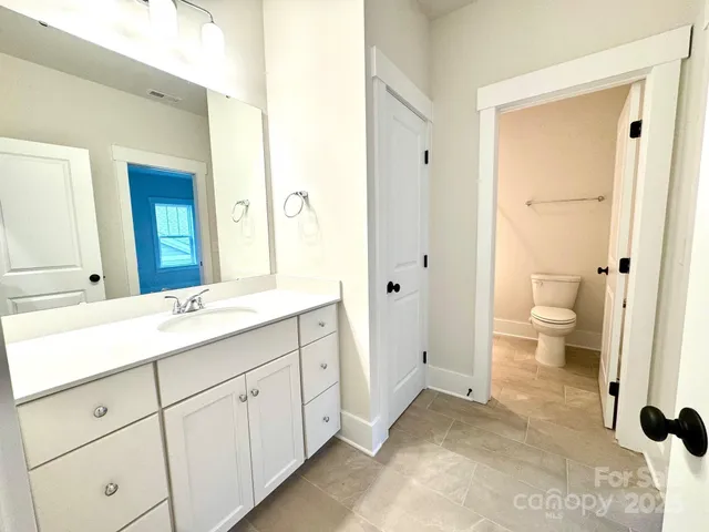 a spacious bathroom with a granite countertop sink toilet and shower