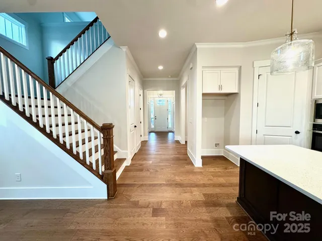 a view of a hallway with wooden floor and staircase