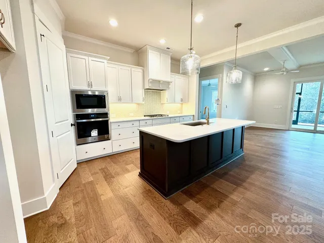 a large kitchen with a large counter top stainless steel appliances and cabinets