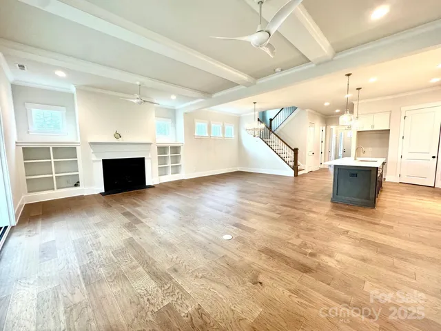 a view of empty room with wooden floor and fireplace