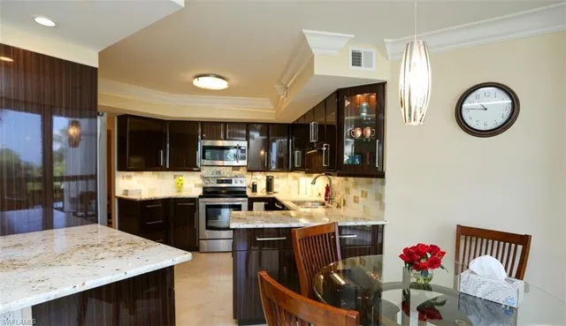 a kitchen with stainless steel appliances granite countertop a stove refrigerator and a sink