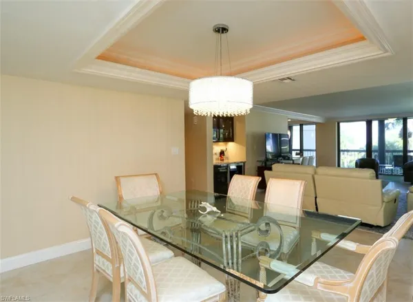 a view of a dining room with furniture a chandelier and wooden floor