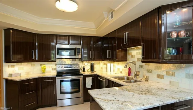 a kitchen with stainless steel appliances kitchen island granite countertop a stove and cabinets