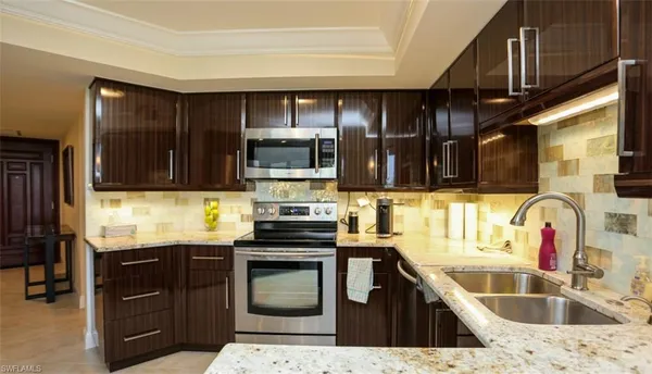 a kitchen with granite countertop a sink and wooden cabinets