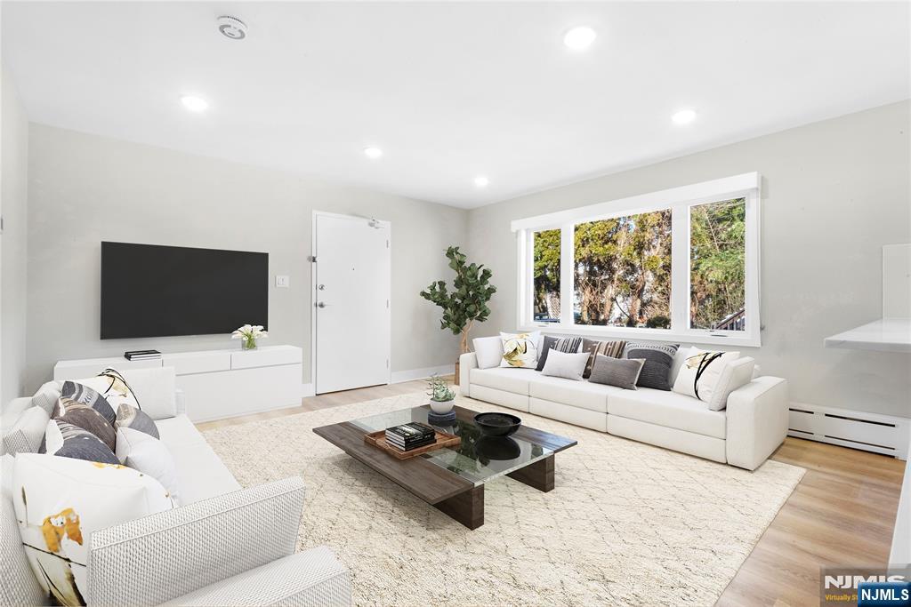 539 Undercliff Avenue, Unit 4 Edgewater, NJ 07020 - Photo 2 of 15 a living room with furniture flat screen tv and a large window