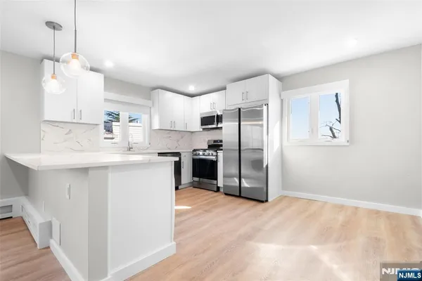 a kitchen with stainless steel appliances a refrigerator sink and microwave