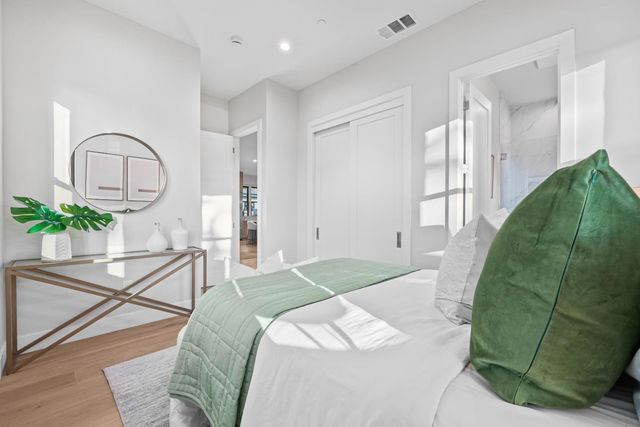 a bedroom with a bed and a potted plant