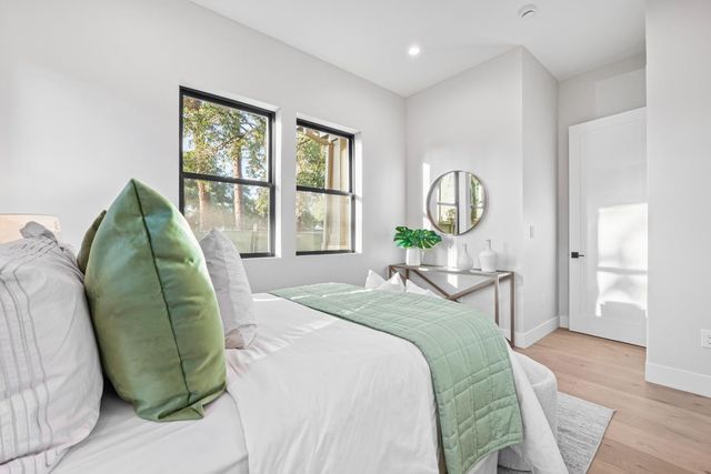 a bedroom with a bed window and mirror