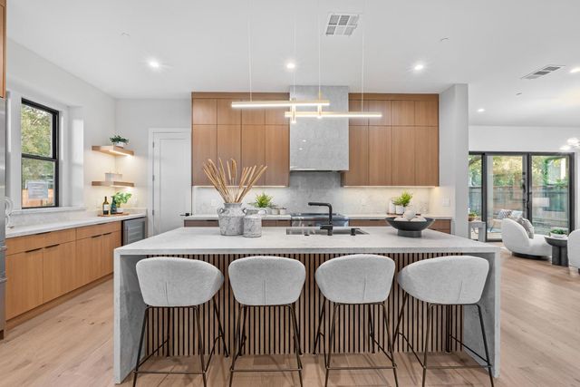 a large kitchen with kitchen island granite countertop a dining table and chairs