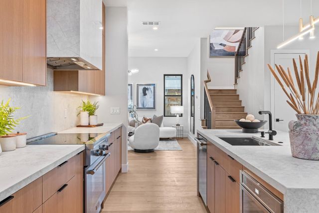 a spacious kitchen with stainless steel appliances kitchen island granite countertop a sink and white cabinets