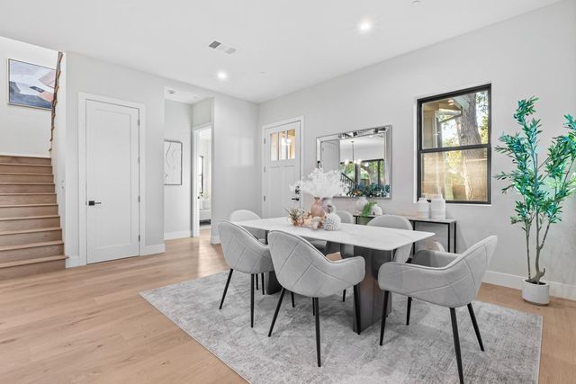 a dining room with furniture potted plants and wooden floor